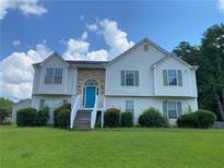 Charming two-story home with stone accents, blue door, and landscaped front yard at 3059 Brass Dr, Austell, GA 30106