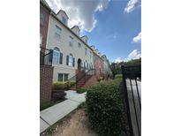 Charming townhome with brick accents, landscaped front, and inviting stairs to the front entrance at 6459 Chariot St # 35, Atlanta, GA 30328