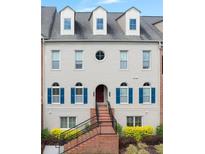 Charming townhome with a brick staircase leading to a stylish front entrance and blue shuttered windows at 6459 Chariot St # 35, Atlanta, GA 30328