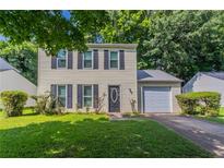 Charming two-story home with a well-manicured lawn and an attached one-car garage at 1377 Mill Lake Cir, Stone Mountain, GA 30088
