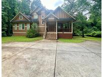 Charming two-story home with a welcoming front porch and well-manicured lawn surrounded by lush trees at 2961 River Ridge Drive Sw, Atlanta, GA 30354