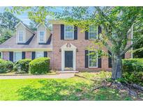 Charming brick home featuring black shutters and a well-manicured front yard at 1797 Emerson Lake Cir, Snellville, GA 30078
