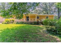 Charming single-story home with a welcoming front porch and a lush green lawn at 2783 Bicentennial Dr, Stone Mountain, GA 30087