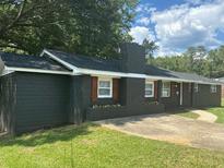 Charming one-story home featuring a classic brick facade, dark shutters, and a well-manicured lawn at 6914 N Baggett Rd, Douglasville, GA 30134