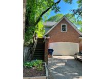 Brick exterior featuring a two-car garage and staircase with lush surrounding greenery at 782 Myrtle Ne St # B, Atlanta, GA 30308