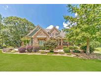 Charming stone home featuring a beautifully landscaped front yard with lush greenery and mature trees at 2010 Bennett Rd, Grayson, GA 30017