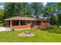Charming brick home with a covered front porch and a well-manicured lawn surrounded by mature trees at 3888 Lindley Cir, Powder Springs, GA 30127