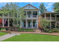 Charming two-story home featuring a double front porch and a well-manicured lawn with black metal fence at 659 Holcomb Bridge Rd, Norcross, GA 30071