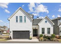 Charming two-story home featuring a black garage door, brick accents, and inviting front entrance at 115 Ivey Way, Woodstock, GA 30188