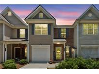 Charming two-story townhouse with a well-manicured front yard at sunset at 299 Azalea Cir, Cumming, GA 30040