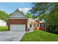 Charming single-Gathering home featuring a brick facade, two-car garage, and well-manicured lawn at 384 Daniel Mill Xing, Villa Rica, GA 30180