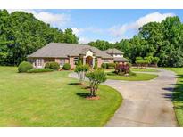 Beautiful brick home featuring lush landscaping, a circular driveway, and a welcoming entrance at 226 Euharlee Five Forks Rd, Kingston, GA 30145