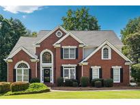 Stately two-story brick home boasts manicured landscaping, charming black shutters, and a welcoming front entrance at 325 Stonecastle Sw Pass, Atlanta, GA 30331