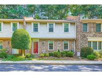 Charming townhouse with shake siding, brick accents, a well-manicured lawn, and a vibrant red front door at 3440 Ashwood Ln, Atlanta, GA 30341