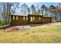 Cozy single-story home with wood siding, front porch and large front yard at 4800 Timber Ridge Dr, Douglasville, GA 30135