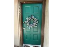 Inviting green front door with a floral wreath, showcasing curb appeal at this cozy home entrance at 3907 Cedar Cir, Tucker, GA 30084