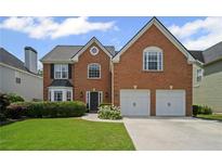 Charming brick home with a well-manicured lawn and two-car garage at 5010 Amber Leaf Dr, Roswell, GA 30076