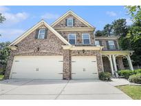 Charming two-story brick home with a well-manicured lawn and a two-car garage, providing ample space at 5696 Walnut Mill Ln, Powder Springs, GA 30127