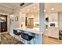 Bright kitchen features white cabinets, quartz countertops, stainless steel appliances, and a breakfast bar with seating at 1 Biscayne Drive Nw # 706, Atlanta, GA 30309