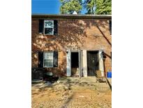 Brick townhouse exterior featuring black shutters, open front door, and patio area at 106 Plantation Dr, Clarkston, GA 30021