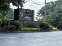 Stone community sign for River West Condominiums with manicured landscaping and street view at 1201 River Green Nw Dr, Atlanta, GA 30327