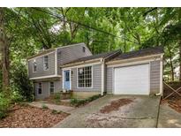 Charming gray two-story home with a blue front door, garage, and a driveway at 4672 Satellite Blvd, Duluth, GA 30096