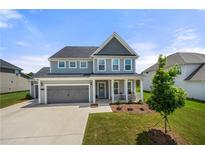 Beautiful two-story home featuring a well-manicured lawn, gray siding, and an attached two-car garage at 916 Gambino Trce, Peachtree City, GA 30269