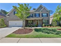 Charming two-story brick home featuring a manicured front yard and attached two-car garage at 13015 Fox Rd, Alpharetta, GA 30005