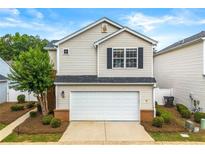 Charming two-story home features a well-maintained lawn, two car garage, and traditional vinyl siding at 486 Windcroft Nw Cir, Acworth, GA 30101