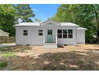 Charming renovated home with a metal roof and a bright, welcoming blue door at 5233 Groovers Landing Se Rd, Acworth, GA 30101