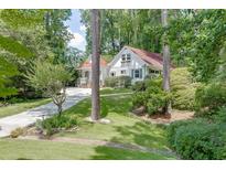 Charming cottage-style home with beautiful landscaping, a stone walkway and driveway through lush greenery at 3219 Parkridge Crescent, Chamblee, GA 30341