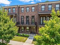 Charming brick townhome with a covered porch and landscaped front yard at 775 Hadley Ne Ln, Marietta, GA 30068