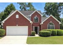 Charming two-story brick home with manicured lawn and attached two-car garage at 200 Ennisbrook Se Dr, Smyrna, GA 30082