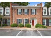 Charming two-story brick townhome with red door and well-maintained landscaping at 5 Palace Green Place Nw, Atlanta, GA 30318