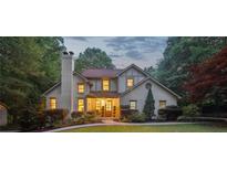 Charming two-story home with brick chimney, lush landscaping and manicured front yard at 205 Pine Lake Dr, Cumming, GA 30040