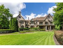 Stunning exterior view of this stone home showcasing its manicured lawn and beautiful architectural details at 170 Autry Trl, Johns Creek, GA 30022