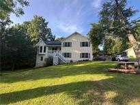 Charming two-story home with a white stairway, blue shutters and a lush green lawn at 1365 Rockmart Rd, Villa Rica, GA 30180
