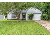 Charming one-story home featuring a well-manicured lawn and an attached single car garage at 5426 Martins Crossing Rd, Stone Mountain, GA 30088