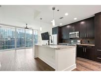 Modern kitchen with stainless steel appliances, island with granite counters, and beautiful dark wood cabinets at 1080 Peachtree Ne St # 804, Atlanta, GA 30309