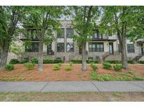 Inviting brick townhome exterior with wrought iron accents and mature trees in a desirable neighborhood at 1598 Aldworth Se Pl, Marietta, GA 30339