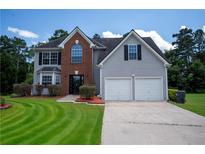 Charming two-story home featuring a manicured lawn, two-car garage, and classic architectural details at 2504 Hannah Haven Dr, Conyers, GA 30012