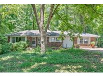 Charming single-story brick home with mature trees and a spacious front yard at 8587 Cumming Se Hwy, Canton, GA 30115