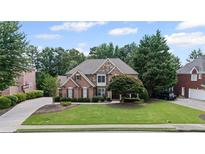 Beautiful brick home features a manicured lawn and mature trees, enhancing its curb appeal at 3560 Greenside Ct, Dacula, GA 30019