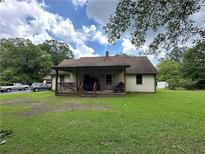 Charming home features a cozy front porch and a spacious green lawn surrounded by mature trees at 3398 Highway 81, Oxford, GA 30054