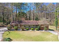 Charming brick home featuring a well-manicured lawn and beautiful landscaping at 9491 Hidden Branch Dr, Jonesboro, GA 30236