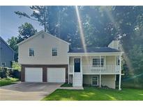 Charming two-story home with a front porch, two-car garage, and lush green lawn at 1011 Darvin Nw Ln, Kennesaw, GA 30144