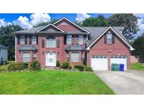 Charming two-story brick home with manicured lawn, two-car garage and classic curb appeal at 1455 Duren Farms Dr, Lithonia, GA 30058
