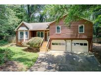 Charming home featuring a two-car garage, landscaped yard, and a cozy front porch at 104 Southfork Dr, Woodstock, GA 30189