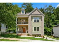 Charming new construction home with a welcoming porch and a second-story balcony, set amidst lush greenery at 3131 Stonegate Sw Dr, Atlanta, GA 30331