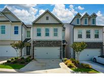 Charming townhome features stone accents, a two-car garage, and professionally landscaped front yard at 428 Whitetail Cir, Canton, GA 30115